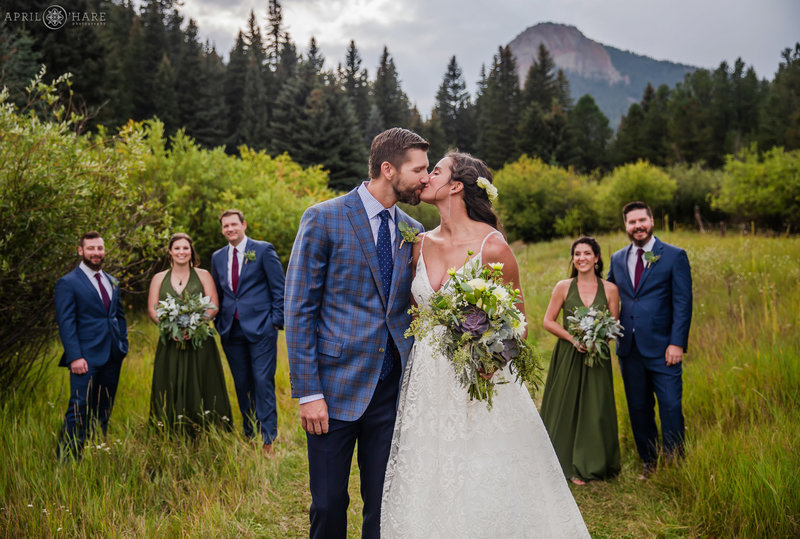Bride and Groom kiss in mountain meadow at Mountain View Ranch in Pine CO