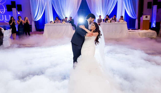 husband dipping his bride during the first dance on the clouds