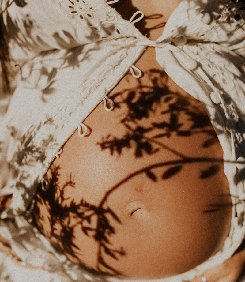 floral shadow over pregnant belly