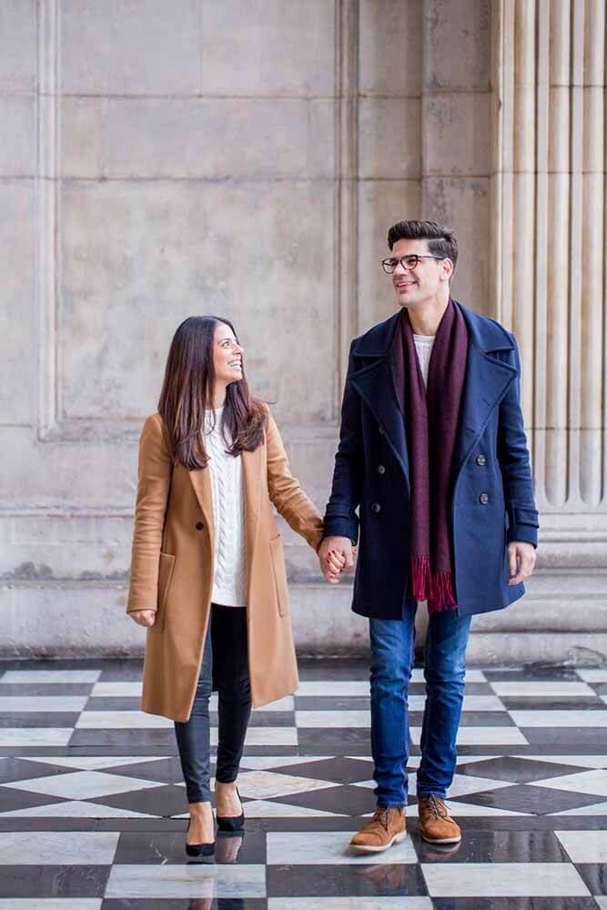 Couple smiling hand in hand at St Pauls Cathedral engagement shoot