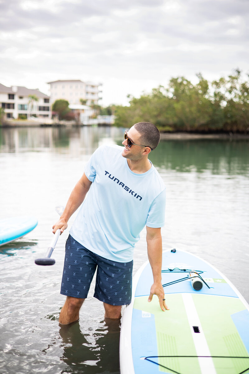Model poses with paddleboard wearing lifestyle gear