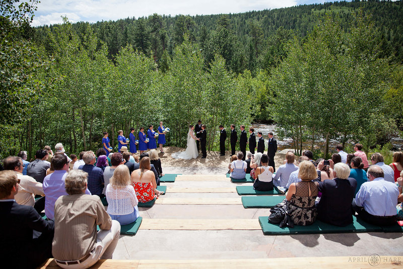 Outdoor wedding ceremony on a sunny day at the River Run ceremony site at Wild Basin Lodge