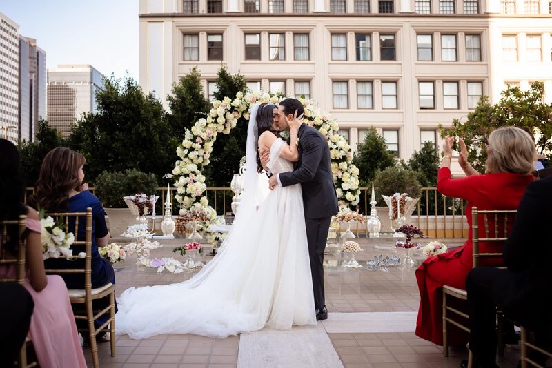 Bride and groom kissing at wedding ceremony at the Westgate Hotel, San Diego
