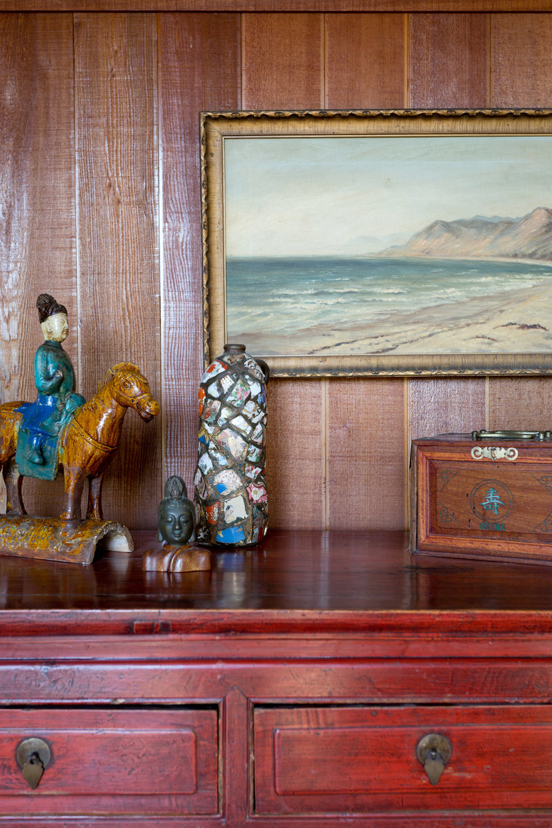 Styling of oriental art collection, and vintage painting on redwood paneled wall
