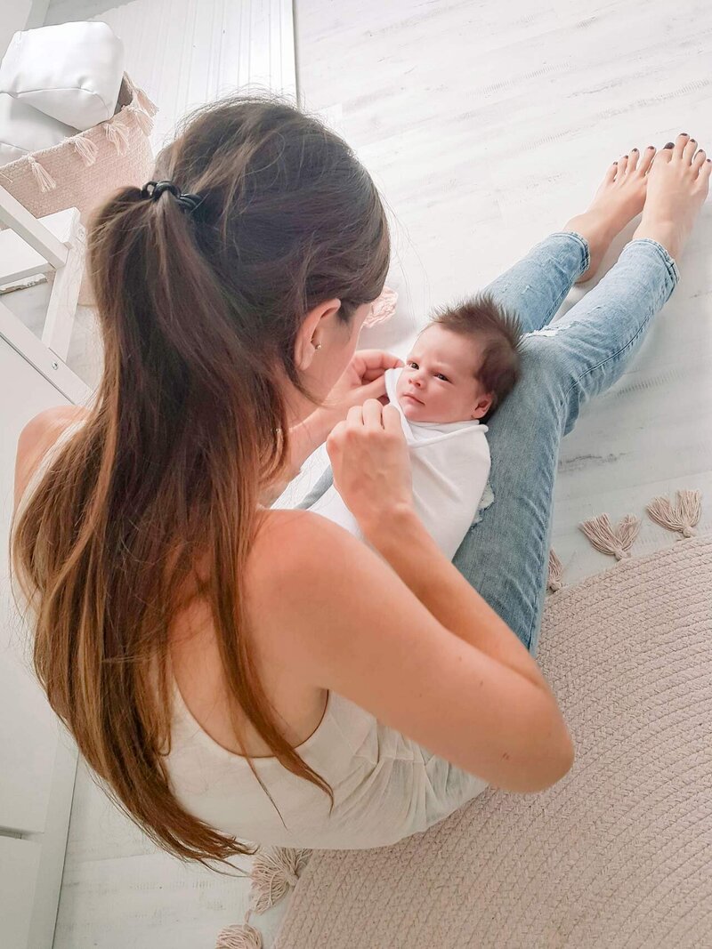 Babyfotografien wickelt Baby während einem Neugeborenen Fotoshooting.