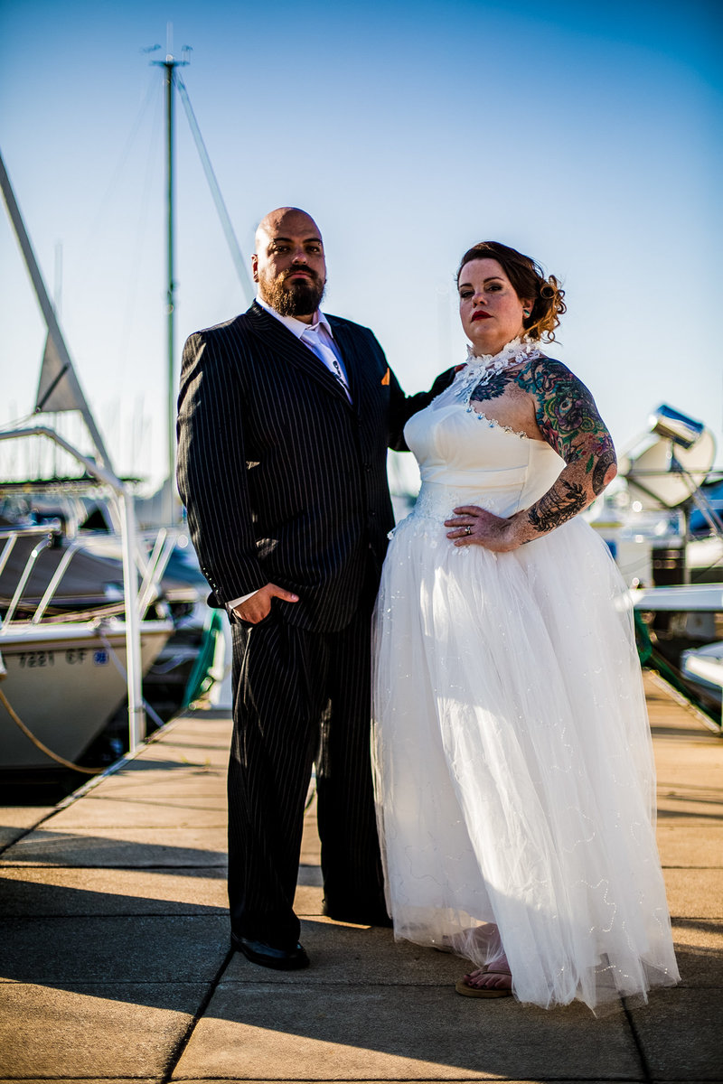 Couple poses among the boats at their Erie Yacht Club wedding