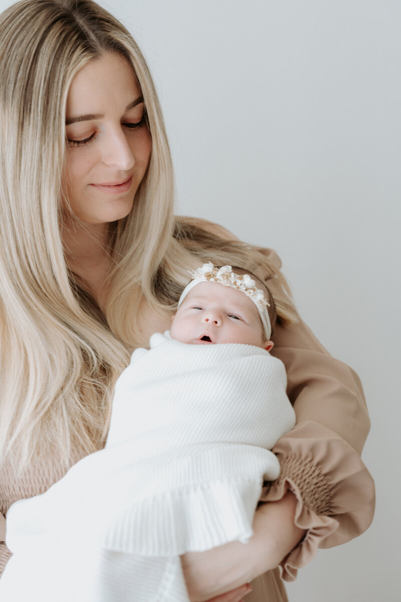 Parents holding their newborn close in a light-filled Perth studio photography session
