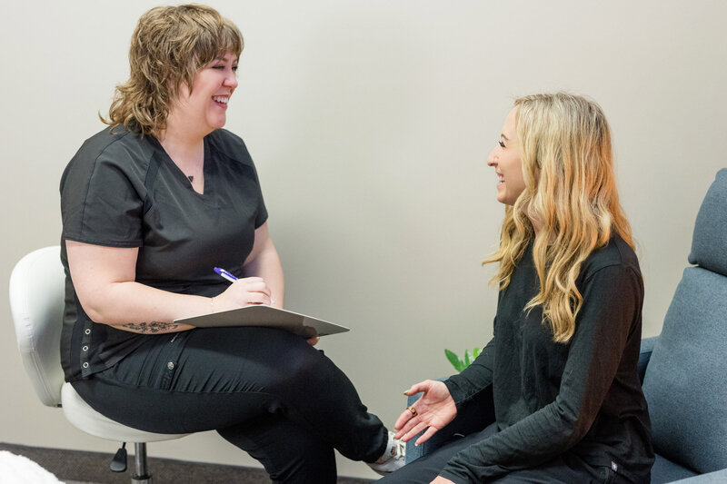 Tara filling out paperwork as she laughs with a patient
