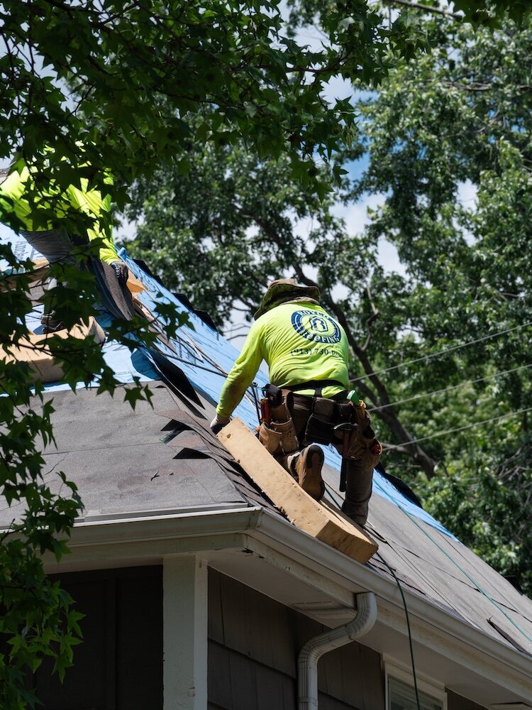 A man on a Kansas City roof is installing new shingles