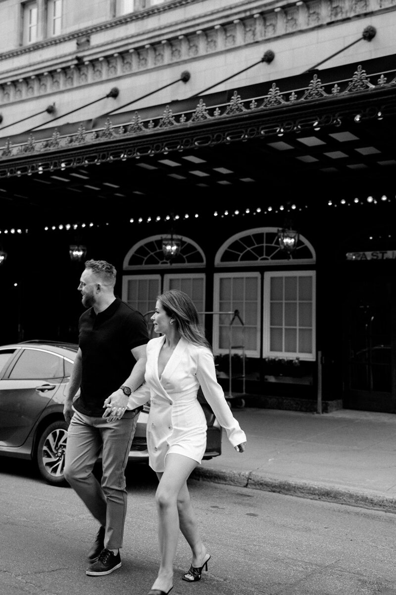 Couple walking, hotel backdrop, chic black and white photo