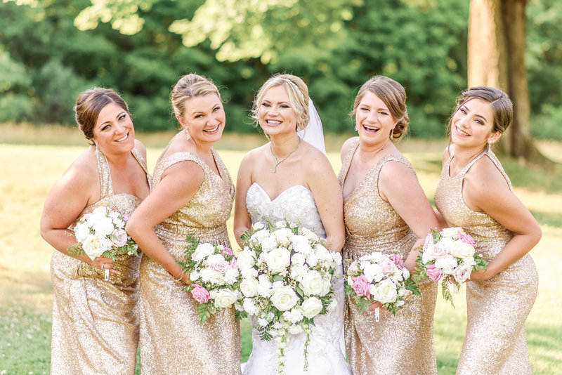 Bride poses with her best friends for a portrait in the park