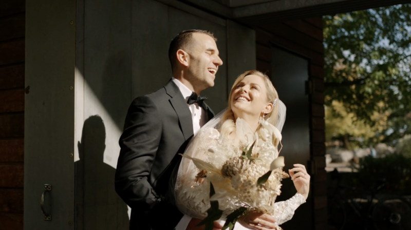 bride holding bouquet while groom laughs