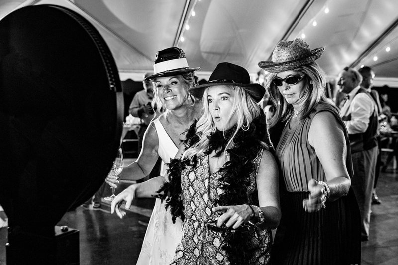 Black and White photo of bride and girlfriends using the photobooth