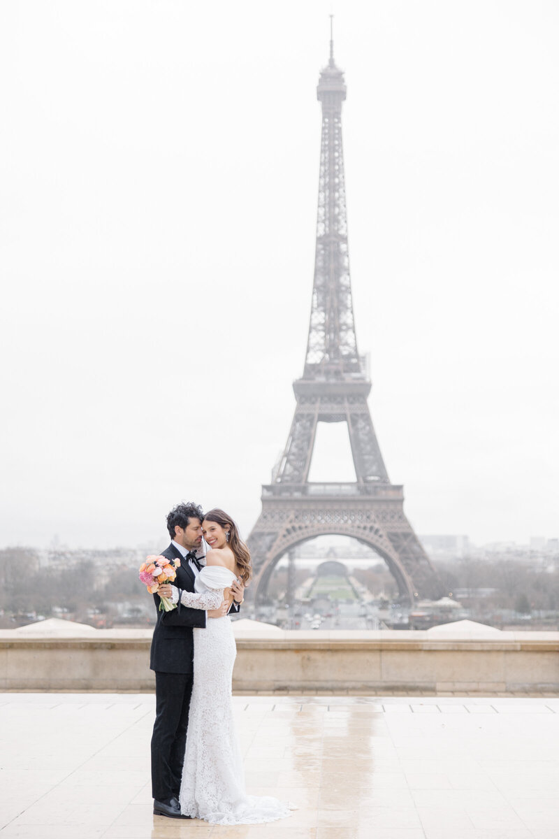 Bride and Groom in front of Eiffel tower in Paris france, photographed by destination wedding photographer brittany navin photography who is based out of Ottawa, ON.