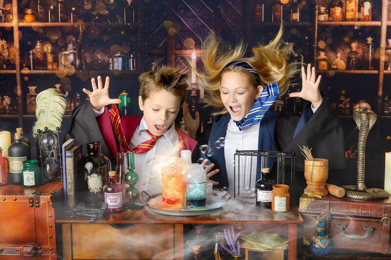 Two siblings make magic in a cauldron at the Wizarding School Portrait event in Myrtle Beach, SC