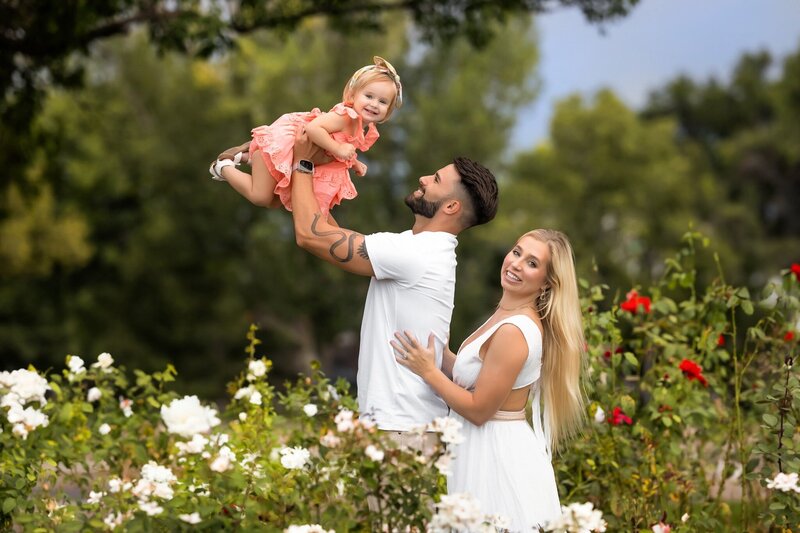 Awesome family posing in front of gorgeous flowers at their denver family photography session with H&N Photography
