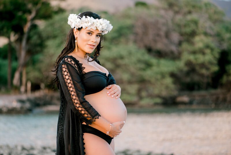 A pregnant woman in a black two-piece beach dress photographed by Mariah Milan