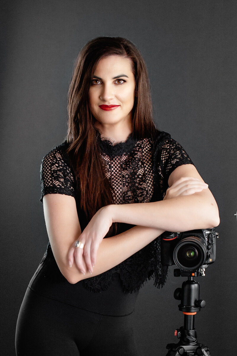 Elizabeth Marie Headshot Girl leaning of camera and tripod with black background