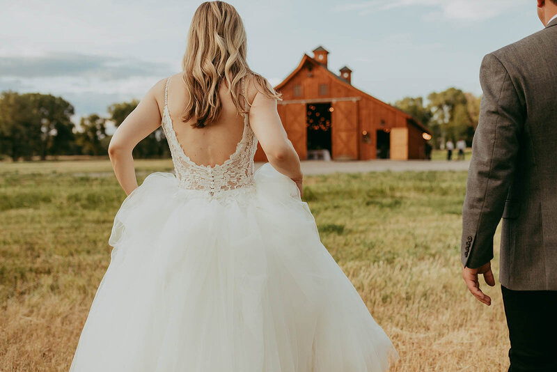 bride and groom in outdoor wedding venue in front of a barn