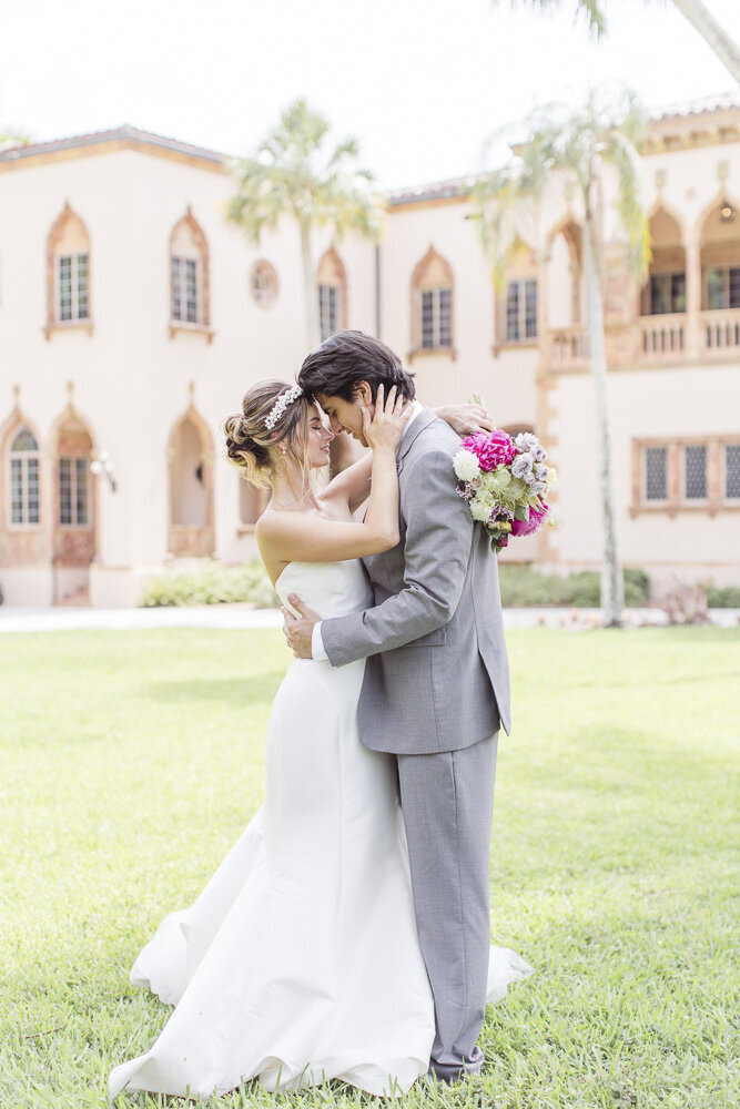 bride and groom embracing in front of wedding venue