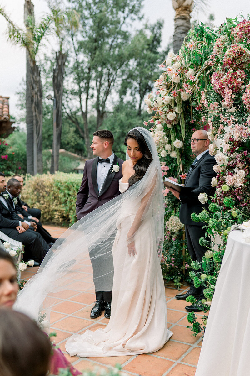 Bride’s veil flowing in the wind during heartfelt vow exchange in a fine art wedding ceremony near Los Angeles