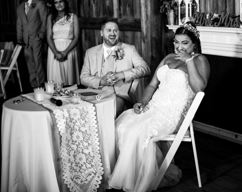 Bride and groom laughing during the toasts at Port Farms wedding reception