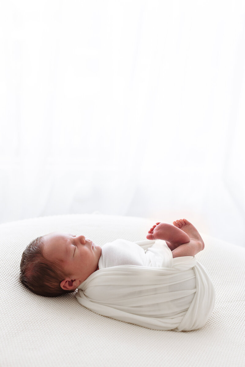 newborn wrapped with feet sticking out