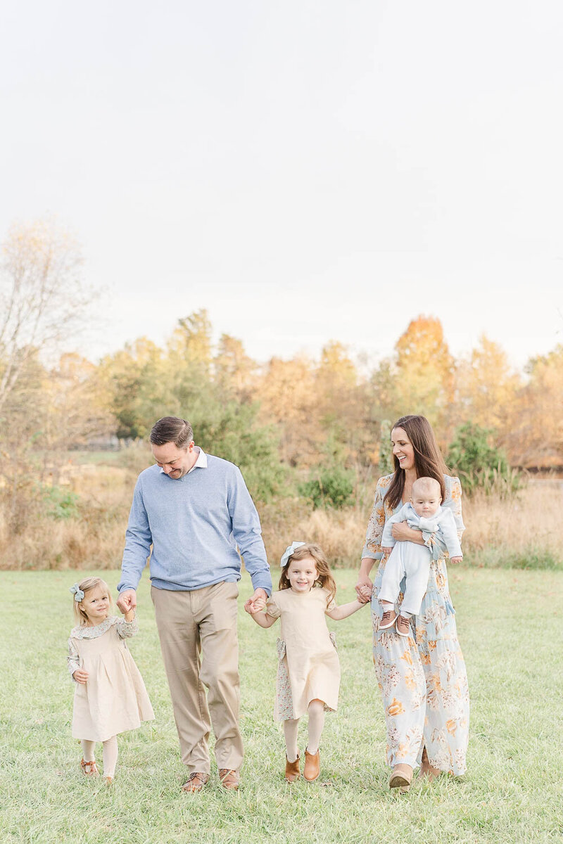 family of 4 walking while looking at each other during Sterling, VA fall mini session