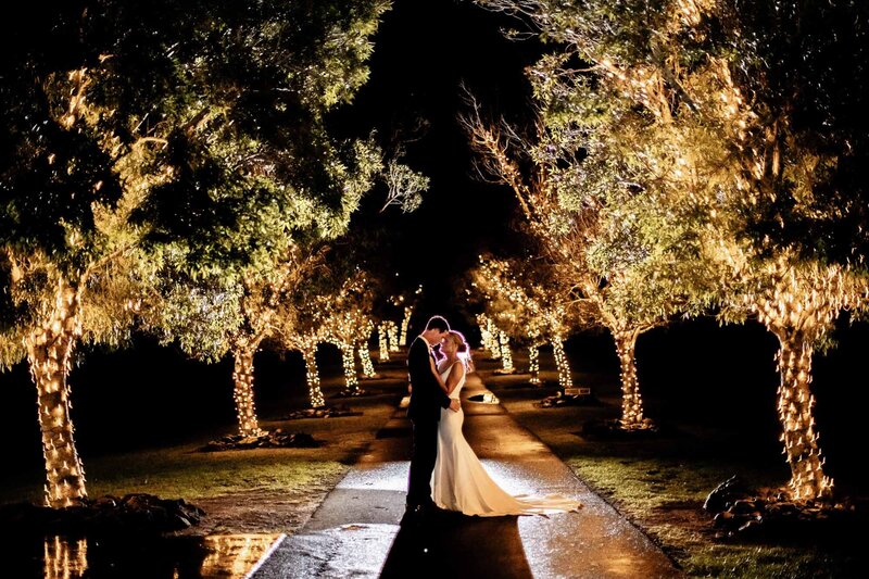 Stunning wedding couple stands in the middle of Preston peak surrounded by night lights