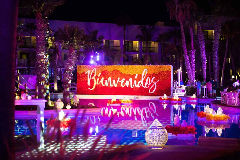 lanterns float in a pool with 'Bienvenidos' displayed in the background.