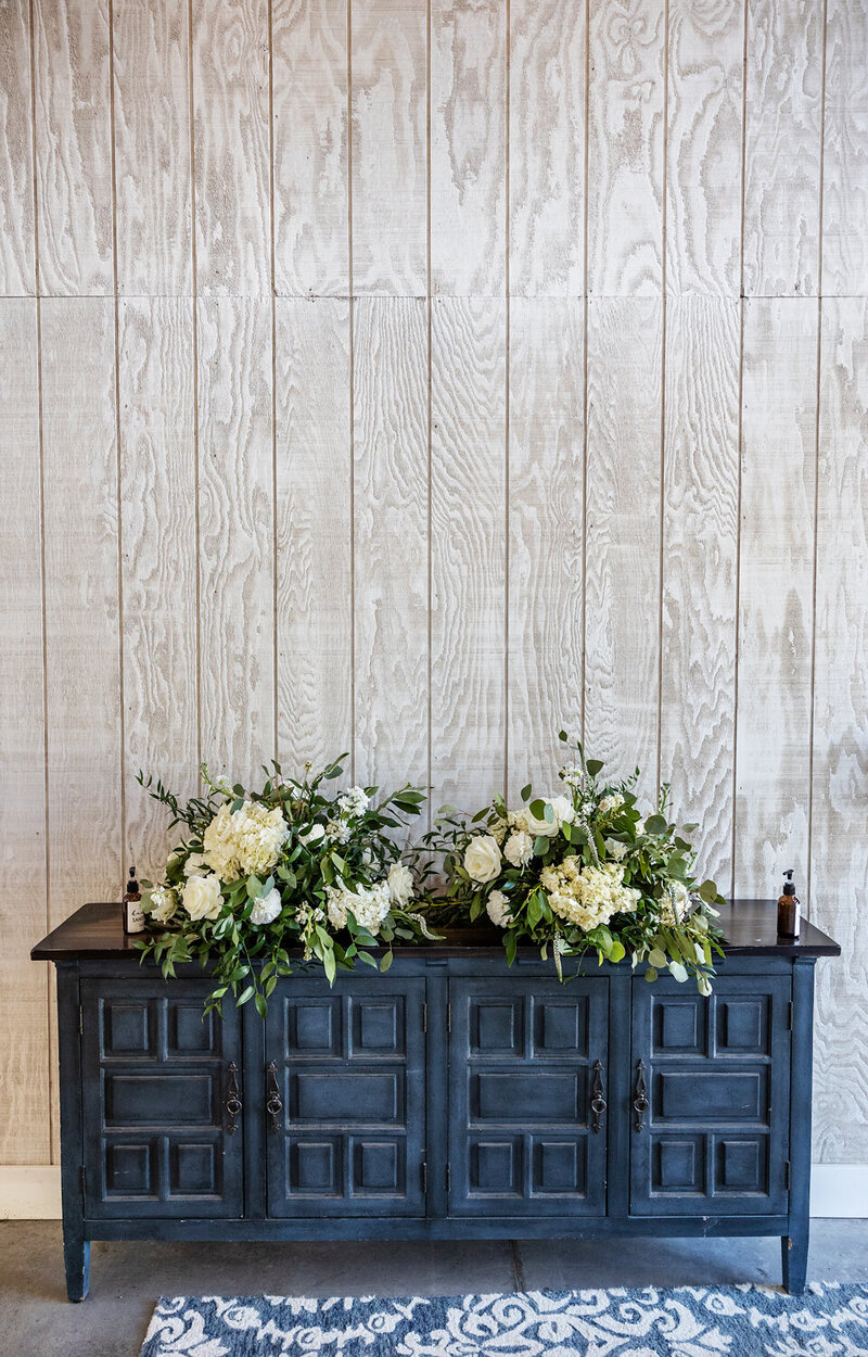 Hallway with blue sideboard table in hallway of Woodlands Barn Wedding Venue