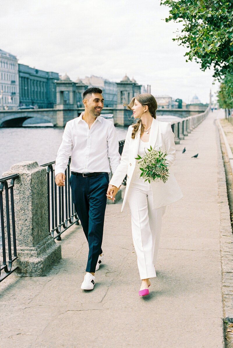 couple-in-white-walking-by-water