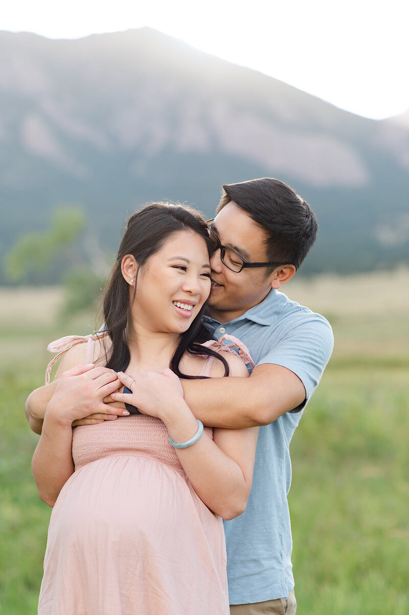 Soon to be mom and dad during a maternity portrait session in Boulder Colorado with the mountains in the background