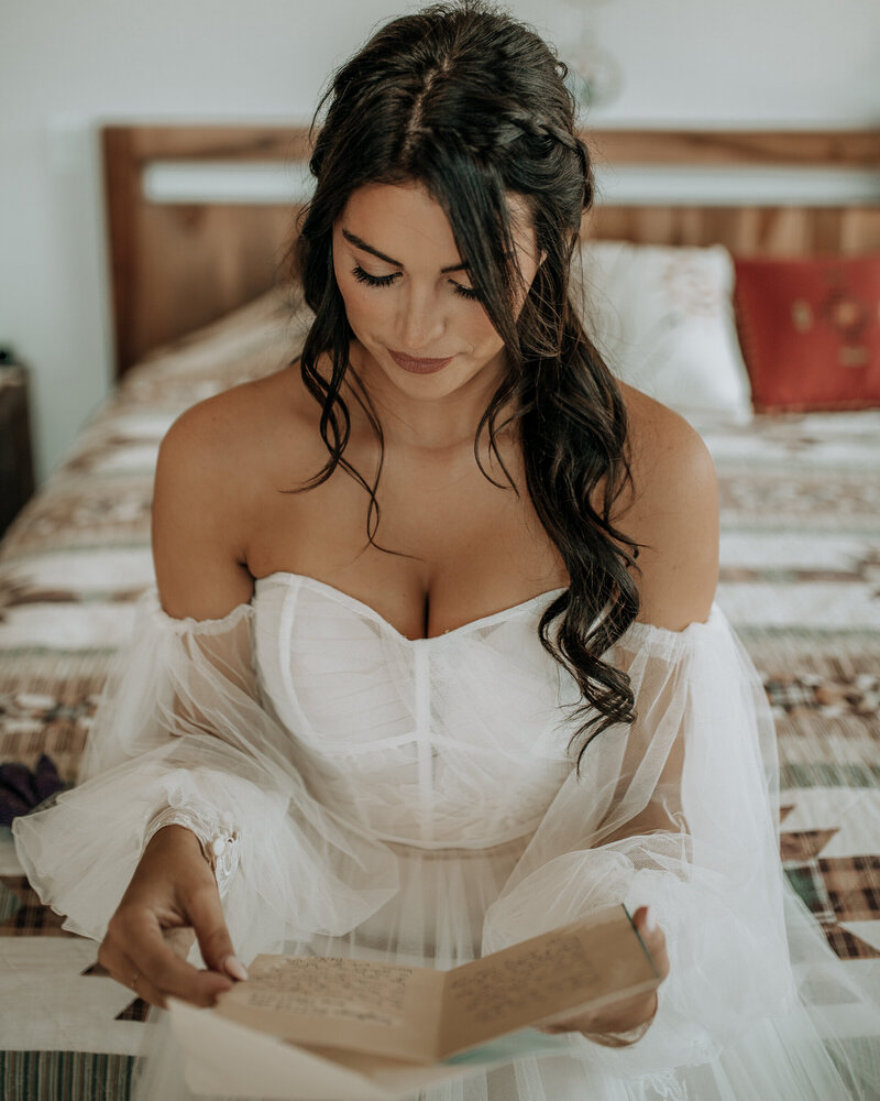 bride reading a letter from her husband on their wedding day in sedona arizona