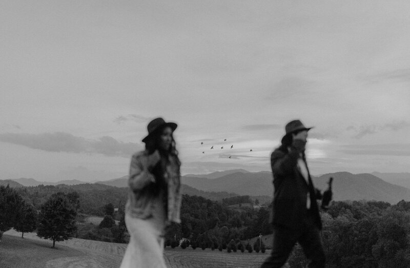 bride and groom walking in front of mountains