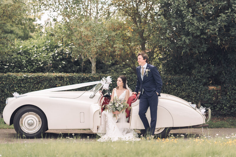 Wedding couple posing my their buckinghamshire wedding car