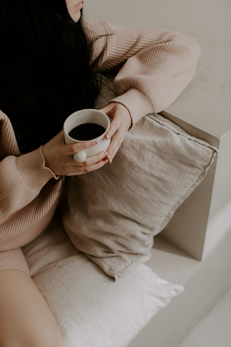 Woman in sweats holding a mug of coffee