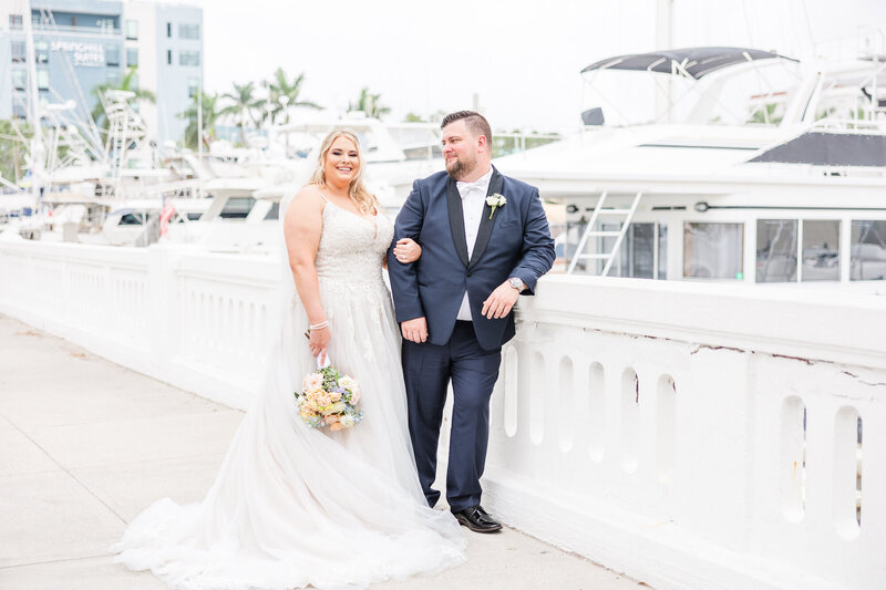 bride and groom walking by yachts and palm trees
