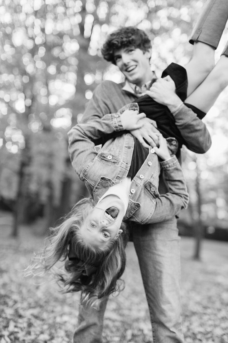 A brother turning his sister upside down in a fun family photo session at Henry Clay in Lexington KY.