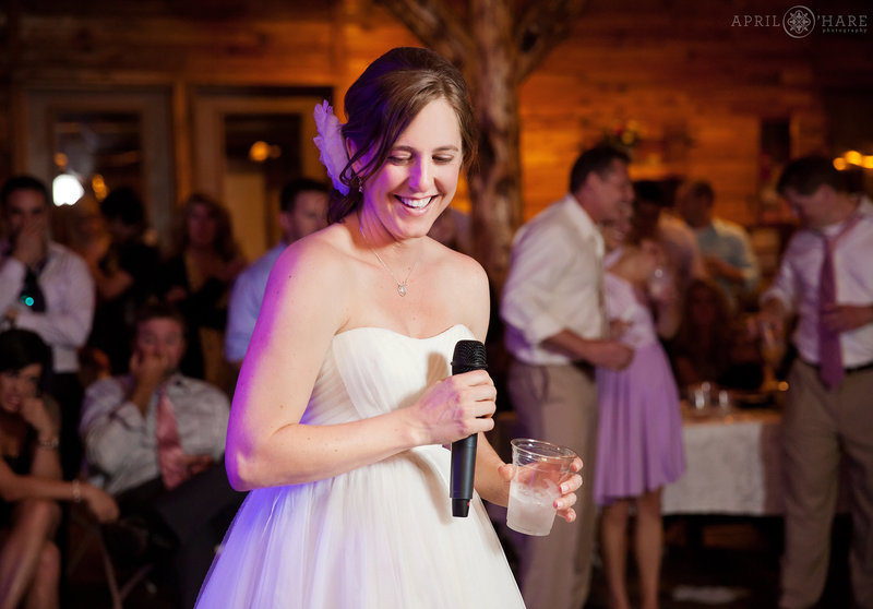 Happy bride at her wedding reception in the rustic barn at Mountain View Ranch in Colorado