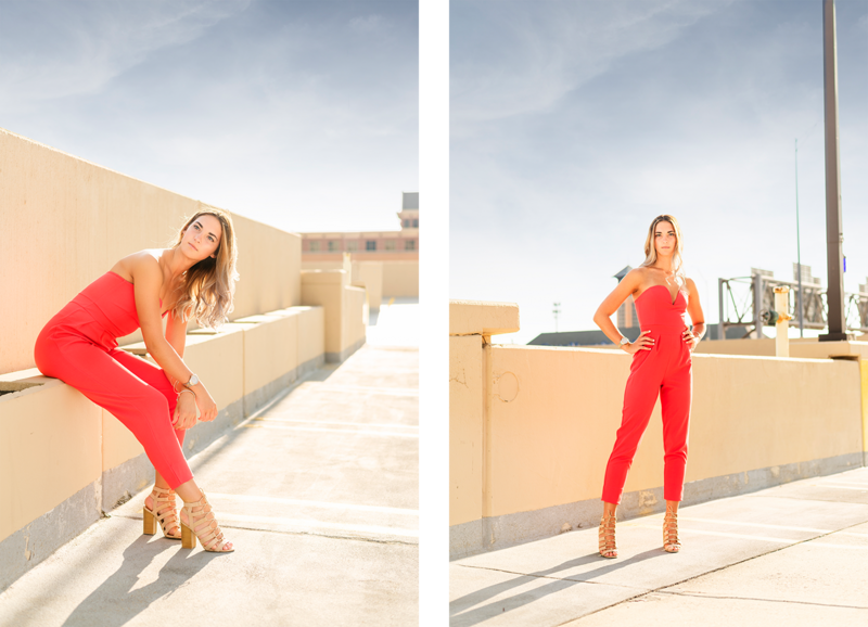 high school senior girl wearing bright red romper and posed on the top of a parking garage