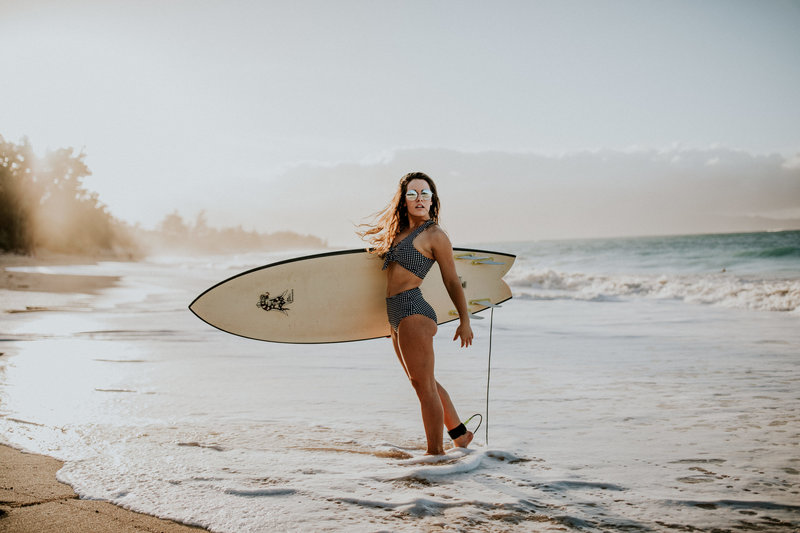 girl at the beach with surfboard