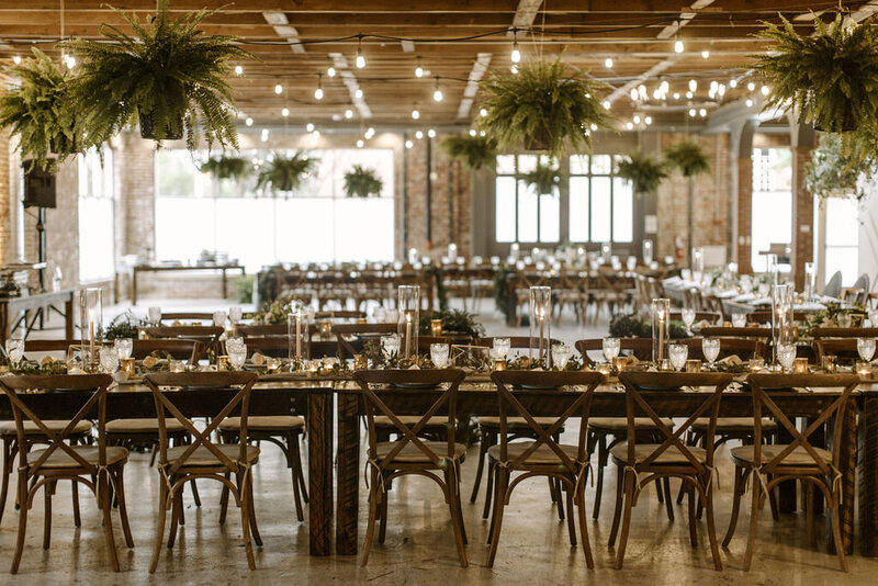Reception set up with hanging greenery, candles and string lights at the St Vrain, boulder county wedding venue
