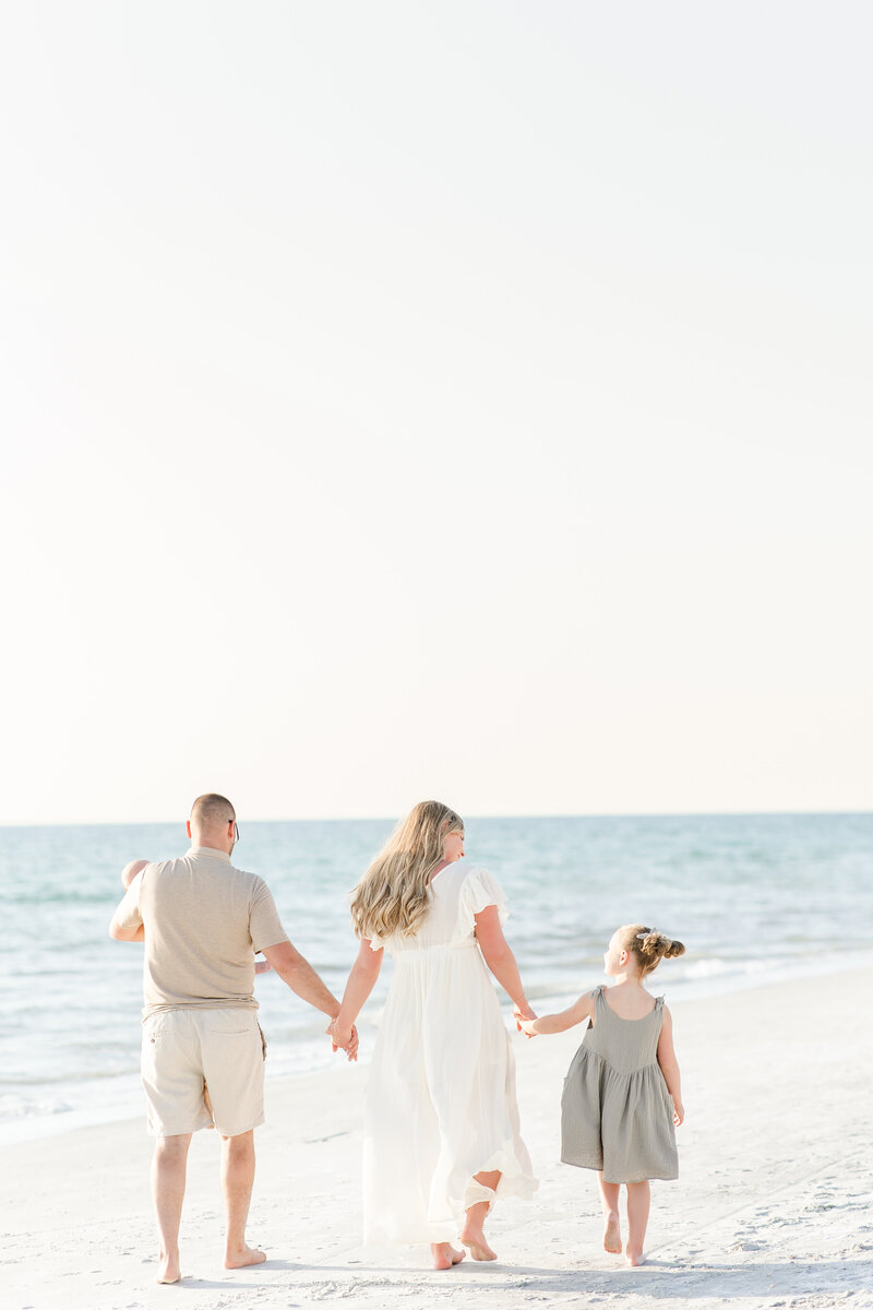 family holding hands on the beach