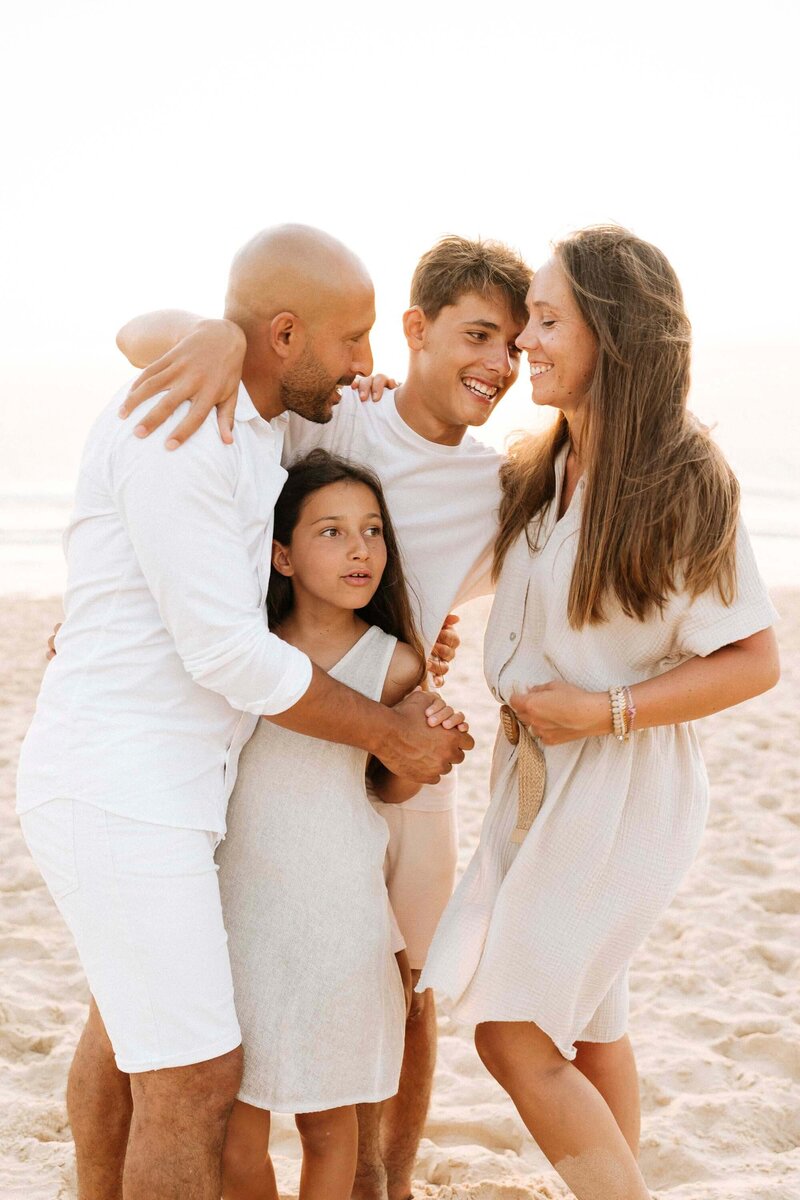 famille de quatre sur la plage habillés en blanc et crème
