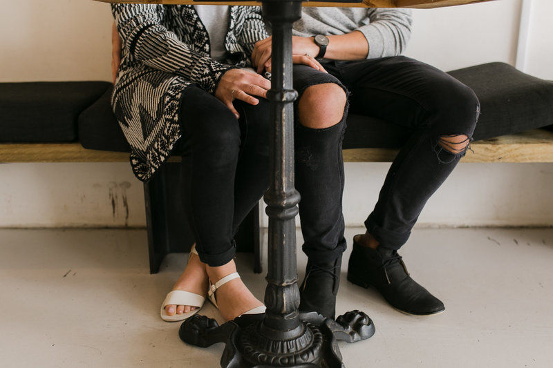 couples legs under table at cafe