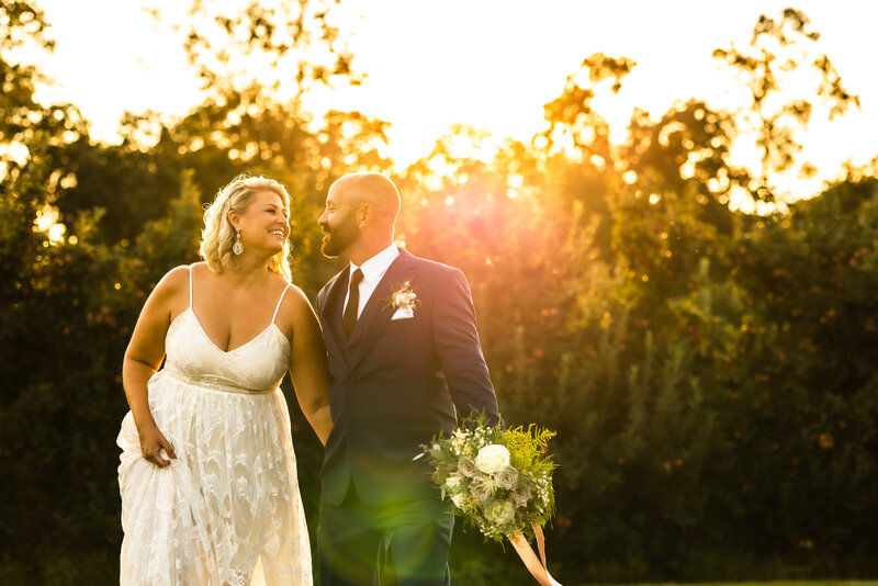 Bride and Groom laugh under a sunset at Browns Orchard, PA Wedding Photographer