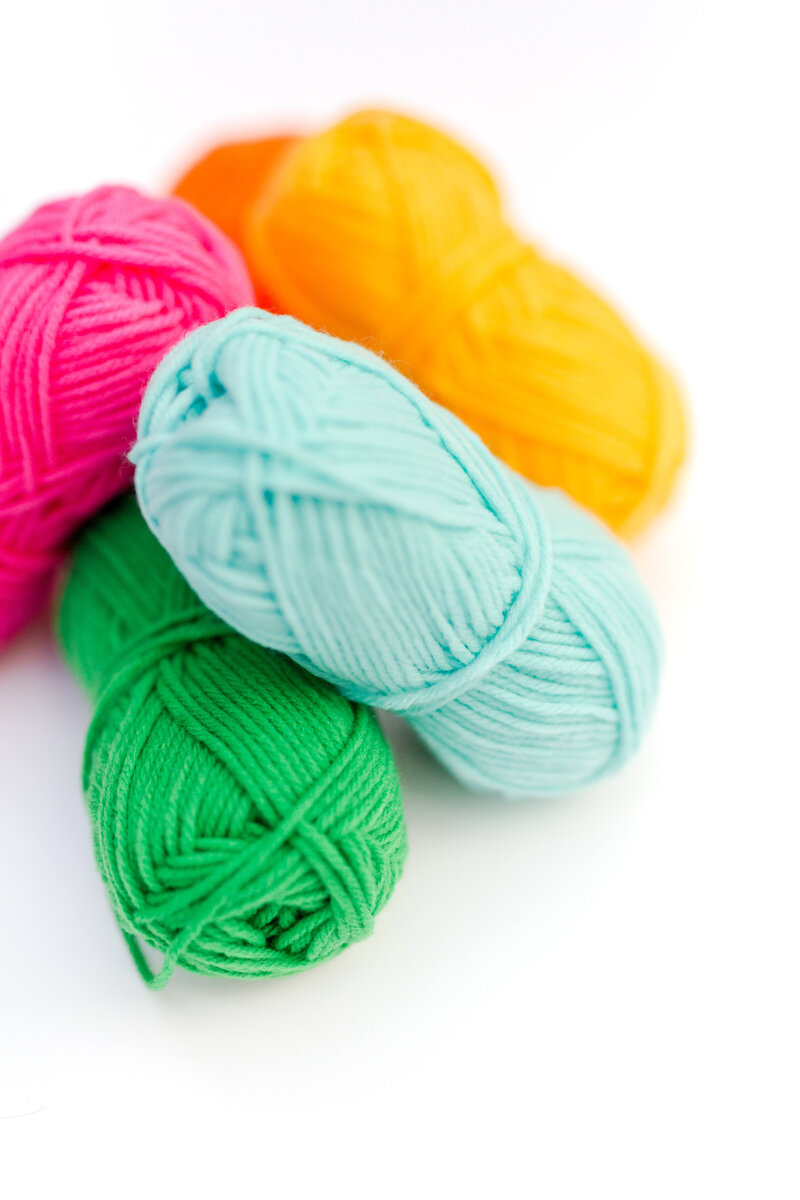 A pile of bright pink, aqua, and bright green yarn skeins - Bloom by bel monili