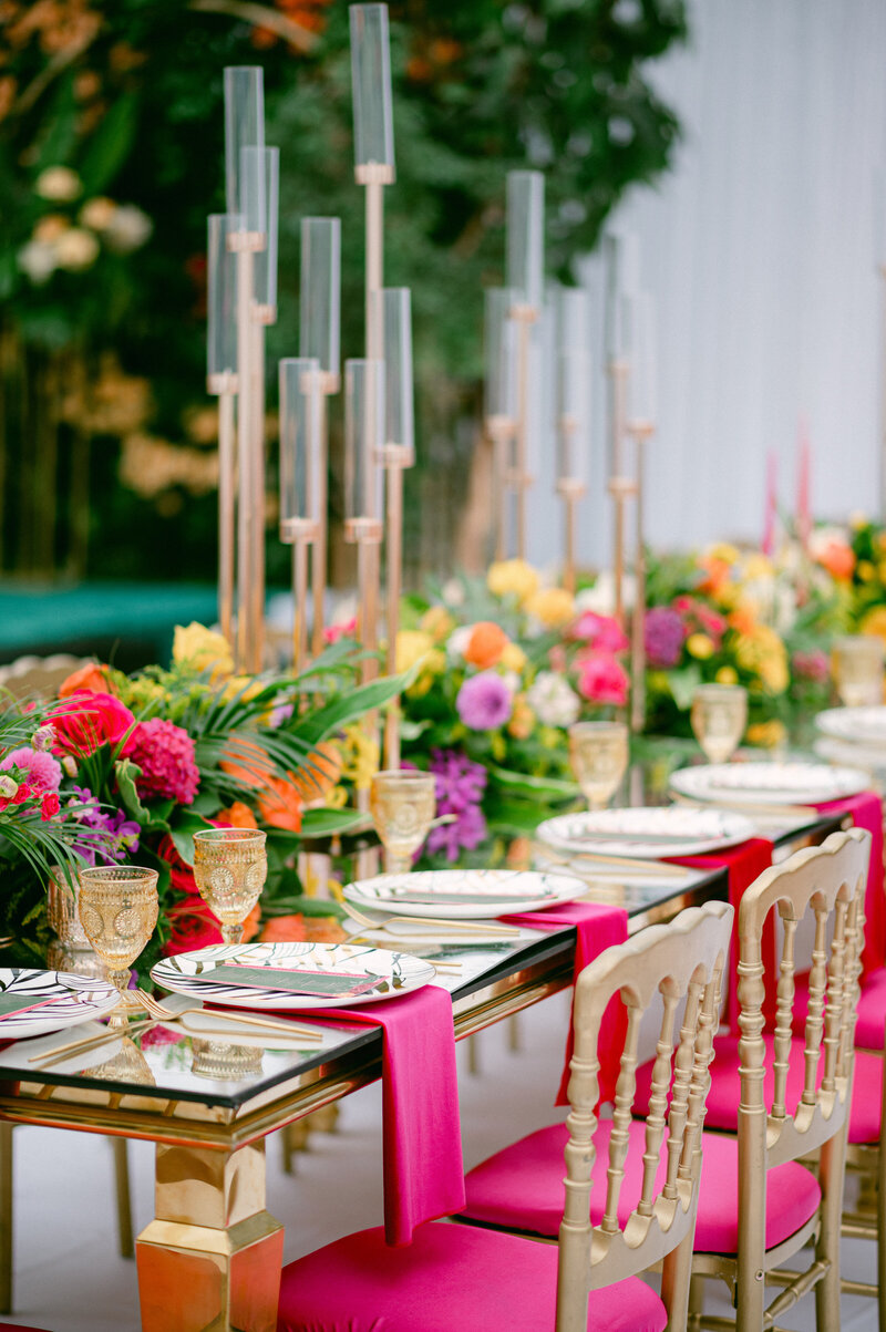 tropical table decoration with pink hankerchiefs and gold cups on the gold table