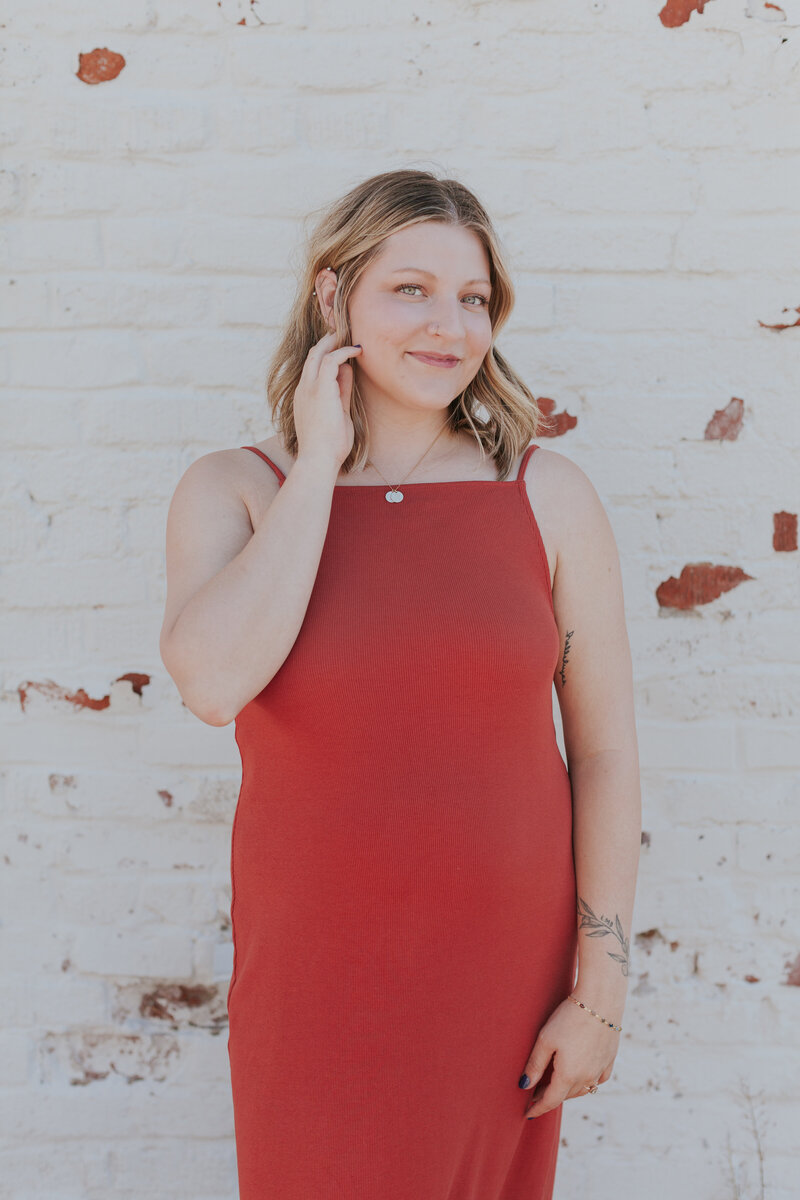 Professional headshot of social media manager Talia Falcon Blackburn in red dress on State Street in Greensboro NC